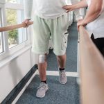 Therapist helps patient to walk