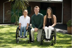 Ed Cummings kneeling between Sam Bloom in wheelchair and Lauren Park in wheelchair